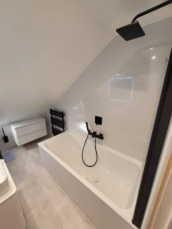 White bath with matt black rainfall shower head